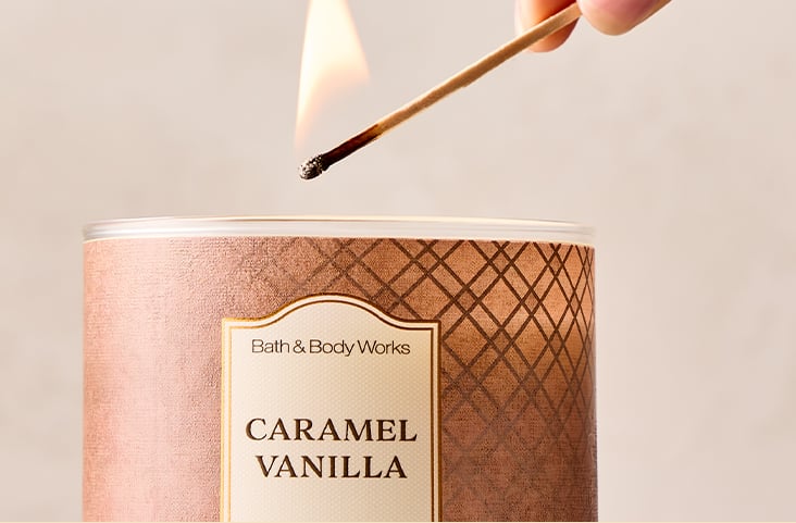 Hand lighting a Caramel Vanilla 3-wick candle